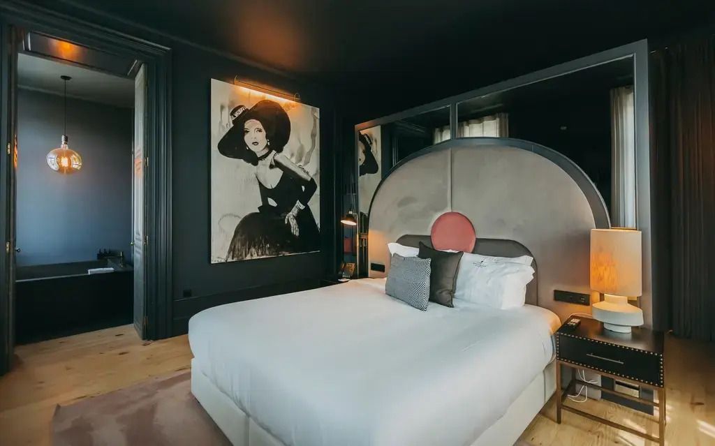 Luxuriöses Doppelzimmer mit kunstvoller Wanddekoration und modernen Möbeln