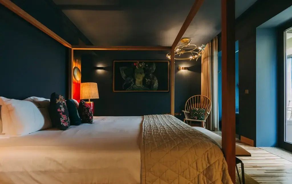 Elegantes Schlafzimmer mit Himmelbett und stilvoller Beleuchtung