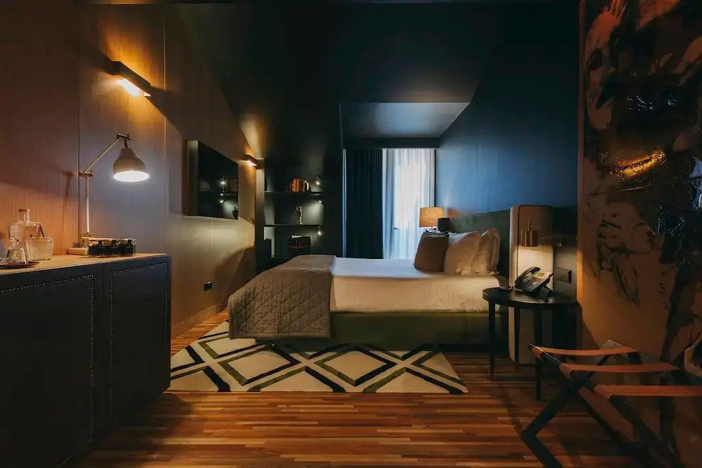 Modernes Hotelzimmer mit stilvollem Dekor in warmen Tönen und gemütlichem Doppelbett.