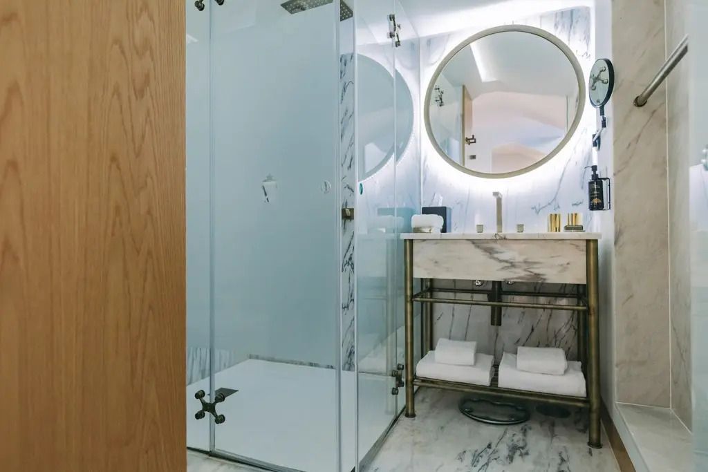 Luxuriöses Badezimmer mit moderner Dusche und eleganter Marmoroptik.