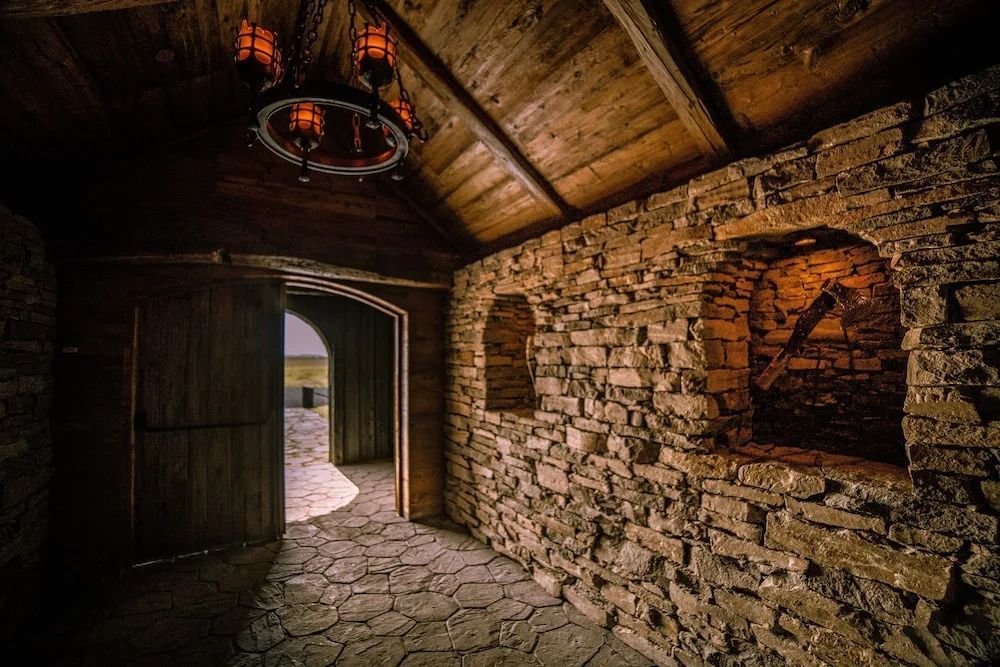 Traditioneller Innenbereich aus Naturstein und Holz mit stimmungsvoller Beleuchtung.