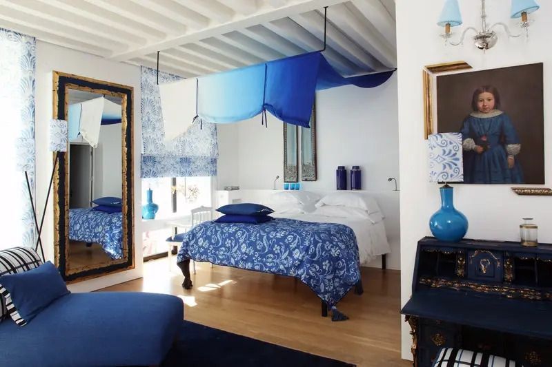 Klassisches Doppelzimmer mit blauen Akzenten und Spiegel.