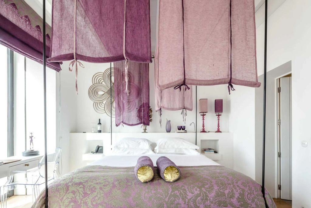 Helles Schlafzimmer mit Doppelbett und dekorativen lila Elementen