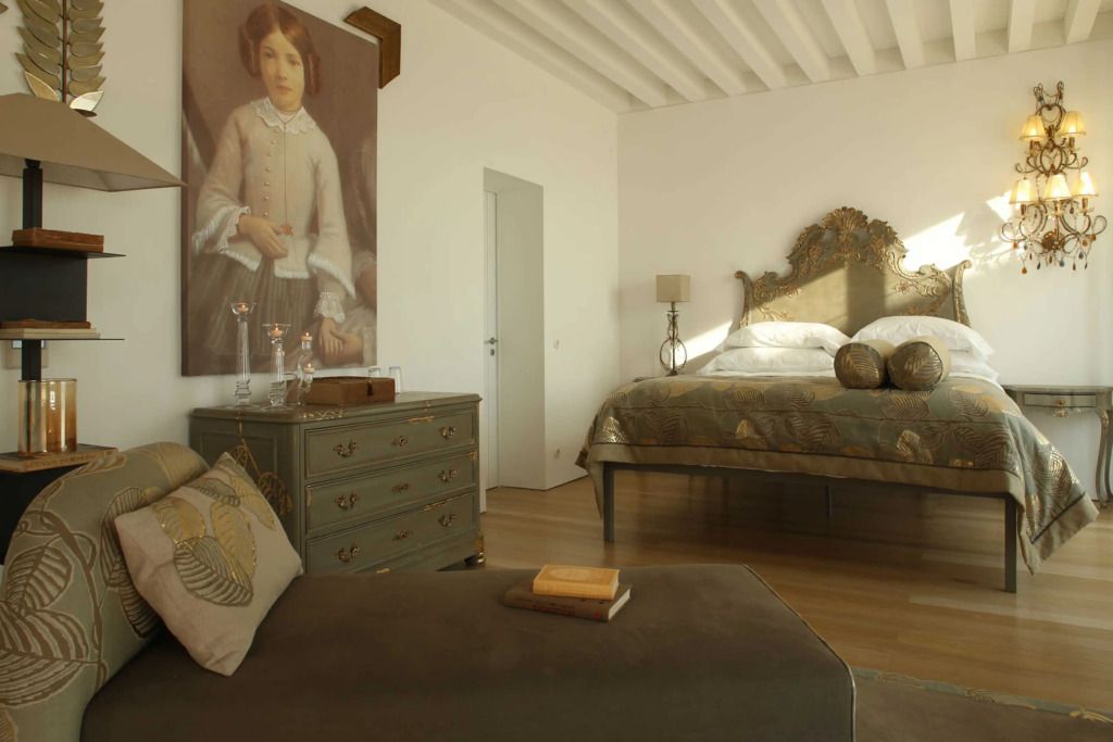 Stilvoll ausgestattetes Schlafzimmer mit antiken Möbeln und großem Kunstwerk