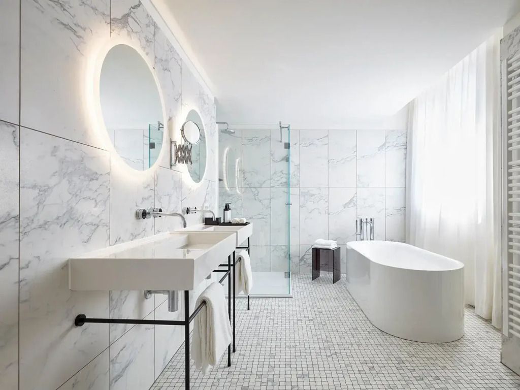Luxuriöses Badezimmer in einer Suite mit freistehender Badewanne und Marmorfliesen