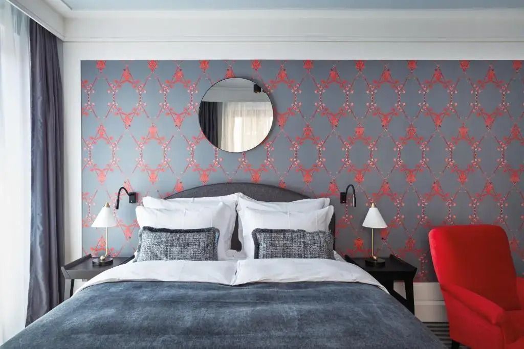 Komfortables Doppelbett in Suite mit eleganter Tapete und Spiegel