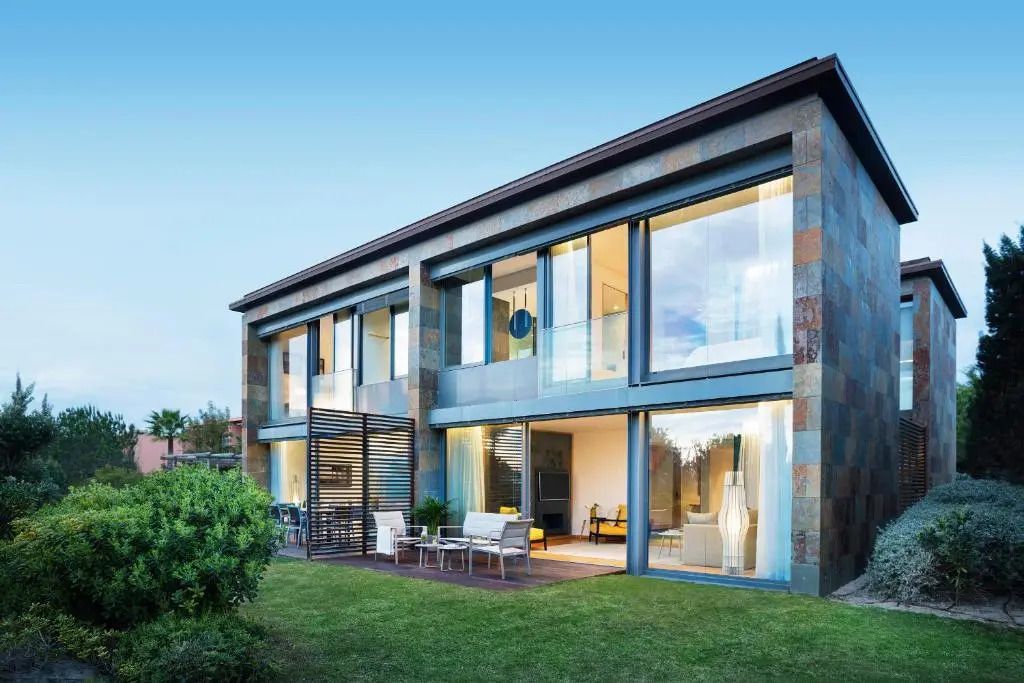 Zweistöckige Moderne Villa mit Glasfassade und möblierter Terrasse