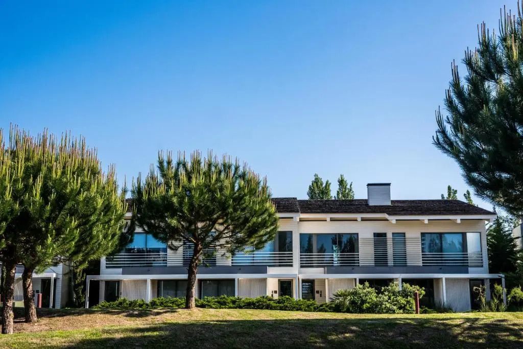 Eingangsbereich der Beach Houses umgeben von grüner Natur und blühenden Bäumen