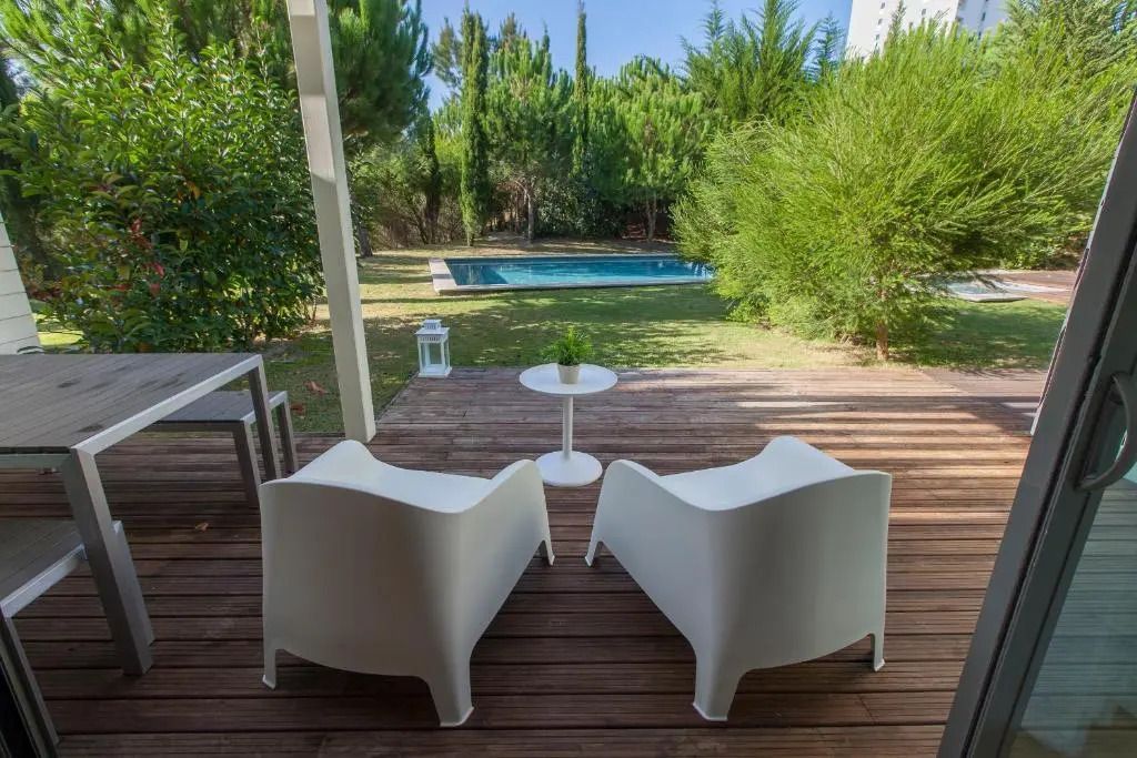 Private Terrasse mit Blick auf den Pool umgeben von üppiger Vegetation