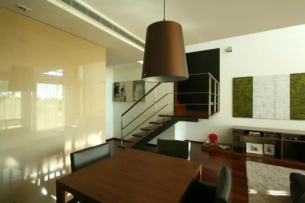 Modernes Interieur mit Esstisch und Treppe in elegantem Apartment