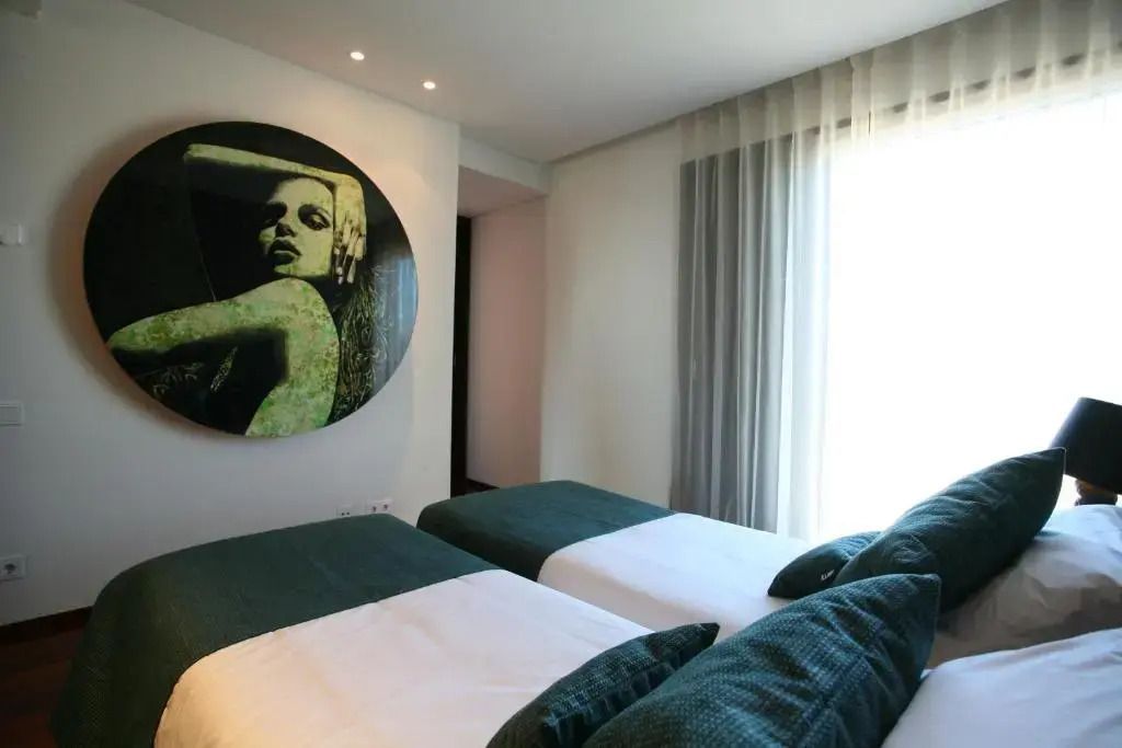 Zimmer mit zwei Einzelbetten und kunstvollem Bild an der Wand