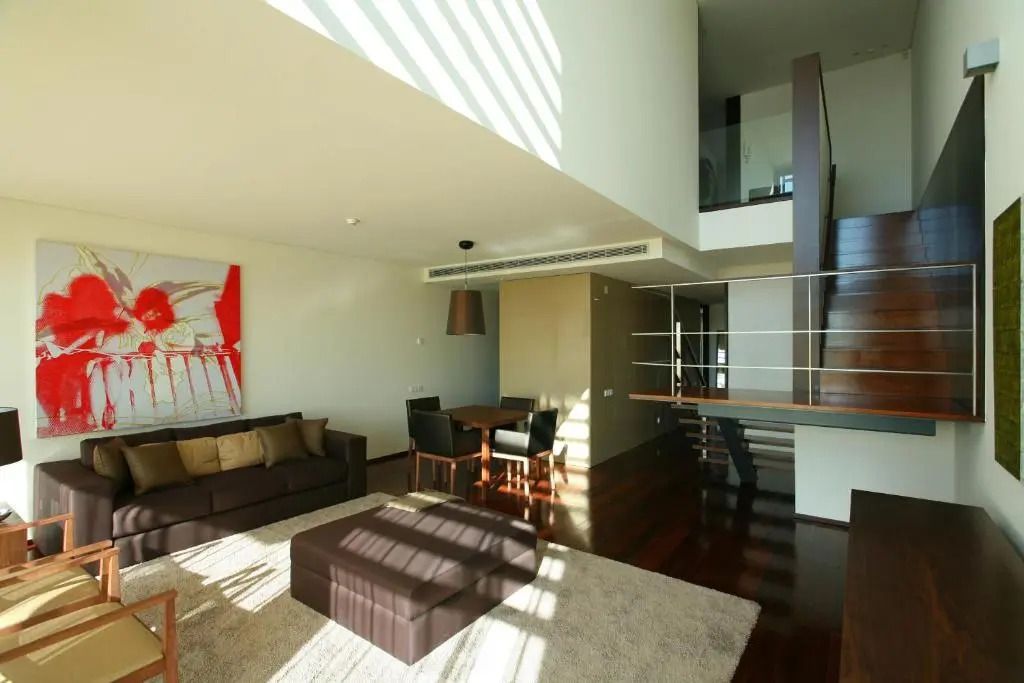 Moderne Wohnlandschaft mit Sofa, Esstisch und offener Galerie