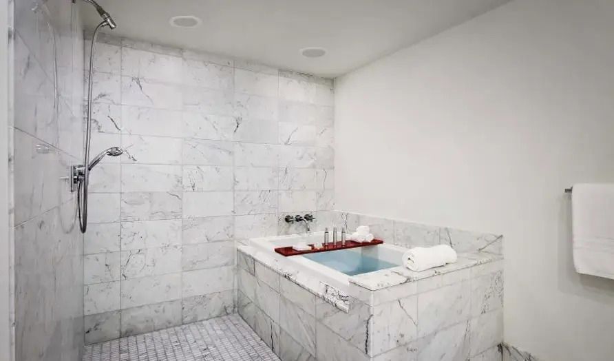 Marmorbad mit eingelassener Badewanne und modernen Armaturen