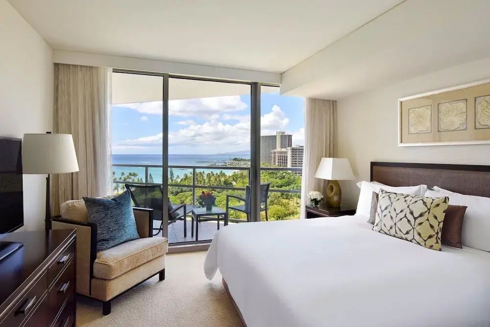 Helles Schlafzimmer mit Balkon und Meerblick im Ka Laʻi Waikiki Beach Hotel