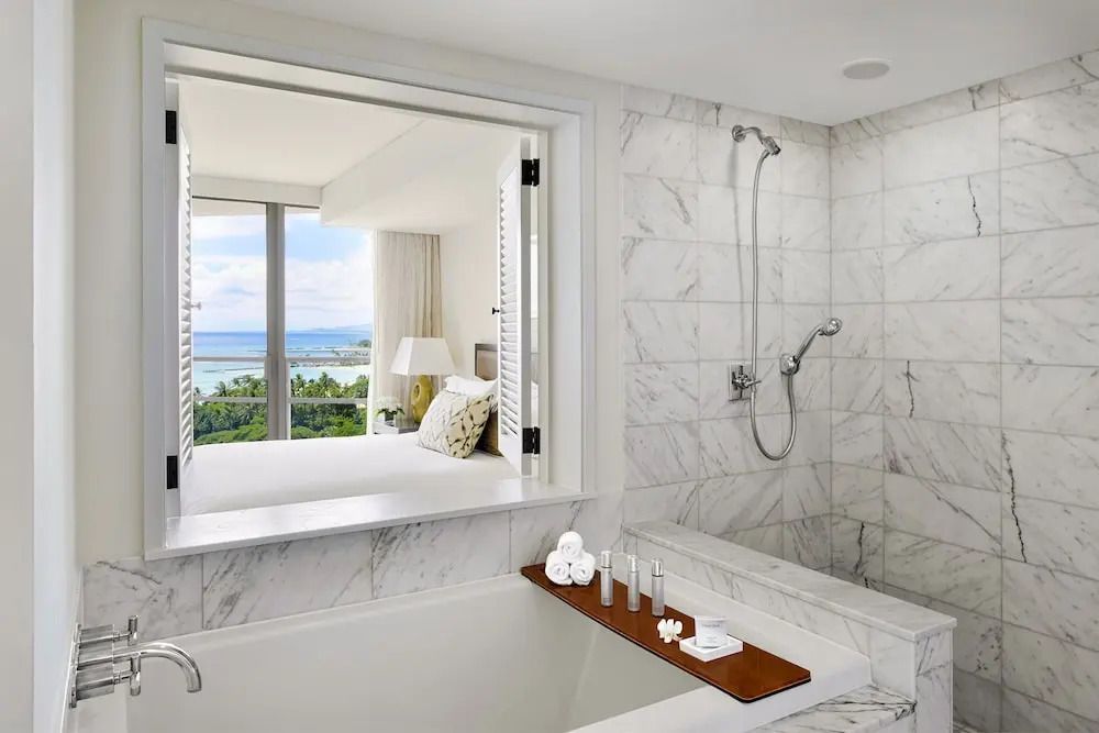 Luxuriöses Badezimmer mit Blick auf das Meer aus einer Suite des Ka Laʻi Waikiki Beach Hotels