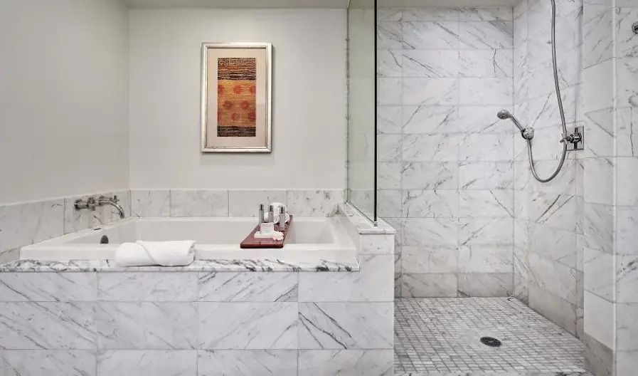 Modernes Badezimmer mit Marmorverkleidung und großzügiger Badewanne