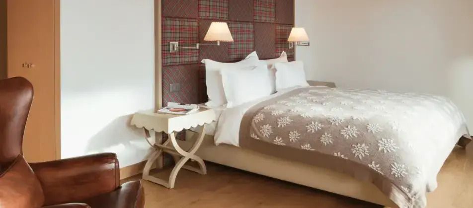 Deluxe Zimmer mit Doppelbett, kariertem Kopfteil und eleganten Lampen