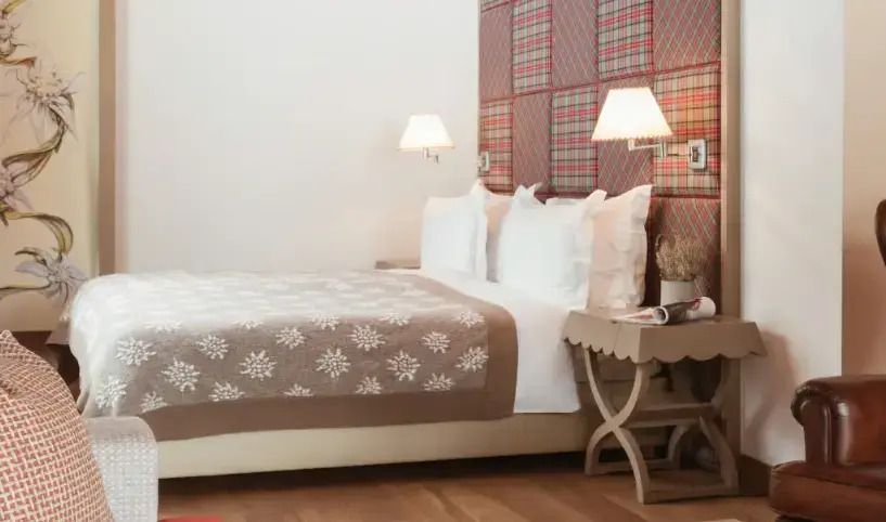 Komfortables Bett mit elegantem Design und traditionellem, kariertem Tapetenmuster