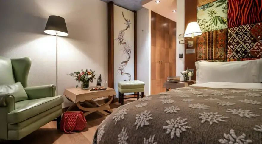 Hotelzimmer mit dekorativem Holztisch und einem roten Handtasche auf dem Boden