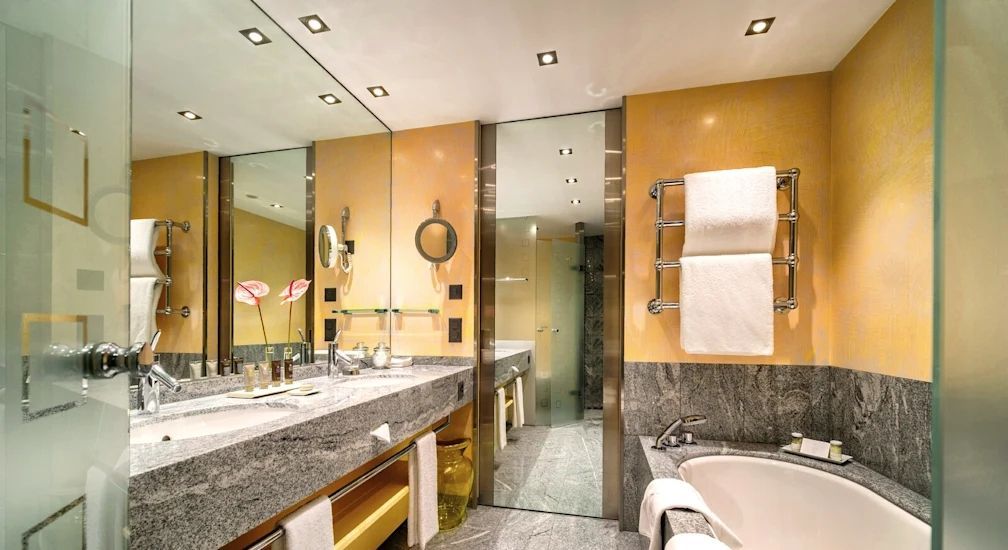 Modernes Badezimmer mit großen Spiegeln und eleganter Badewanne.