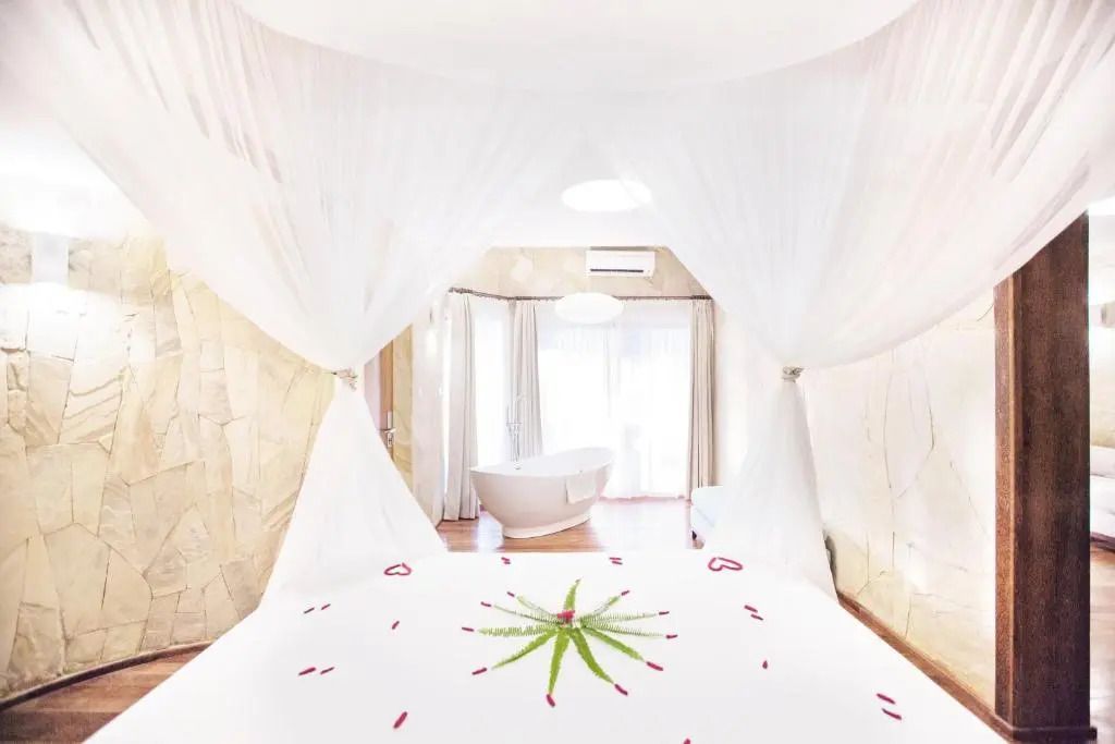 Luxuriöses Schlafzimmer mit Himmelbett und freistehender Badewanne