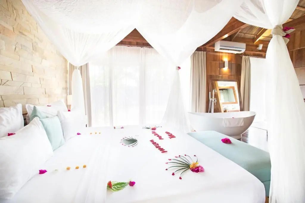 Helles Schlafzimmer mit Himmelbett und dekoriertem Bett in der Royal Villa