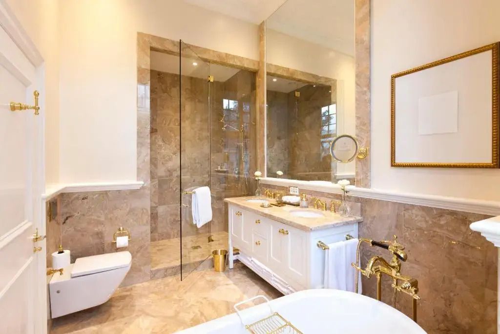 Elegantes Badezimmer mit goldenen Akzenten und einer großen Dusche