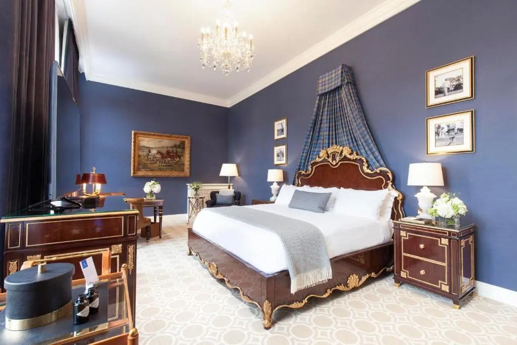 Opulentes Schlafzimmer mit einem großen Bett und blauen Wänden