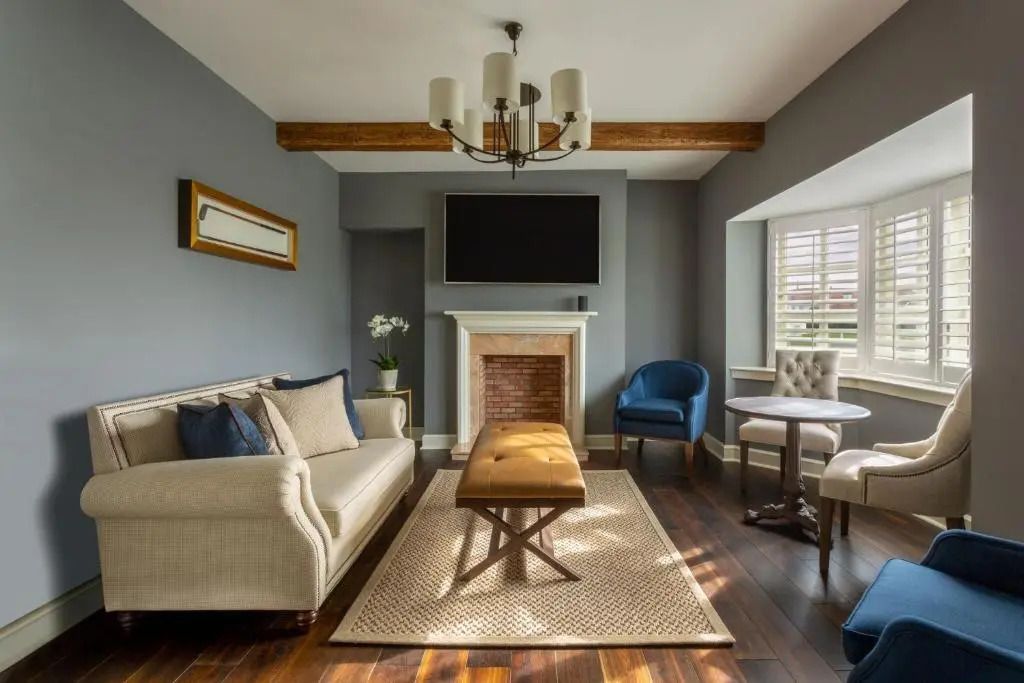 Stilvolles Wohnzimmer mit Sofas, Kamin und Holzbalken