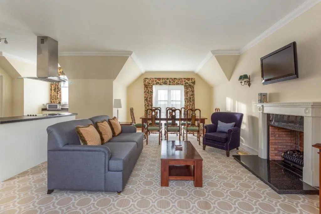 Elegantes Wohnzimmer einer Villa mit Sofa, Esstisch und Fernseher.