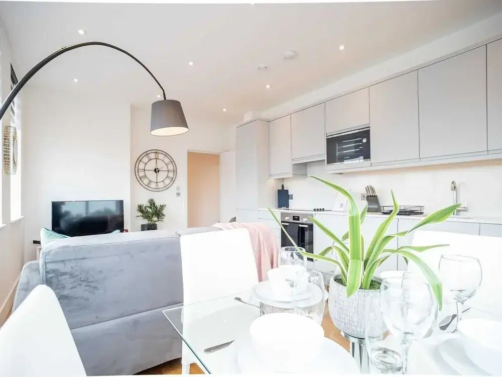 Helles Wohn- und Esszimmer eines Apartments mit moderner Küche.