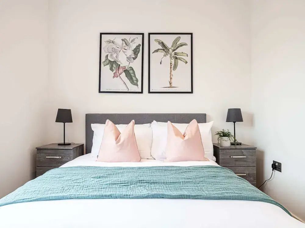Helles, komfortables Schlafzimmer mit Designer-Kissen und Pflanzenkunst.