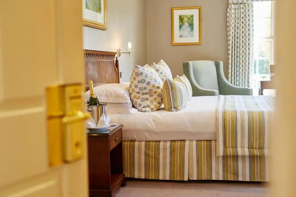 Elegantes Deluxe Zimmer mit Kingsize-Bett und gemütlichen Kissen, Blick auf stilvolles Interieur.
