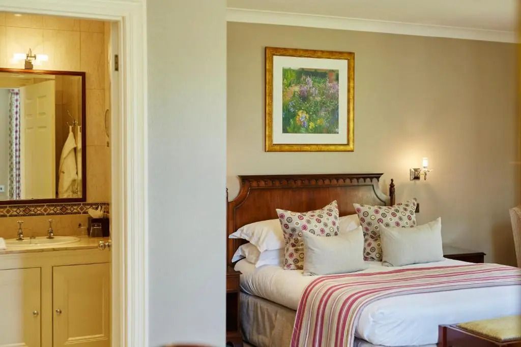 Hotelzimmer mit Doppelbett, Blumenmusterkissen und Kunst an der Wand