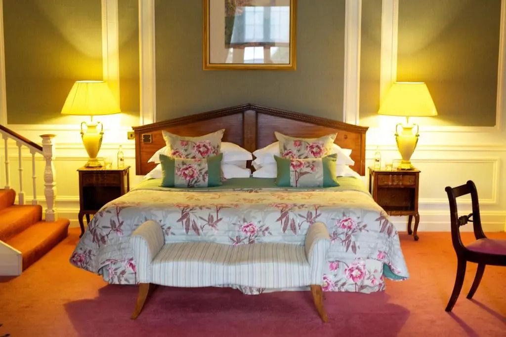 Luxuriöses Hotelzimmer mit großem Bett und floralem Dekor.