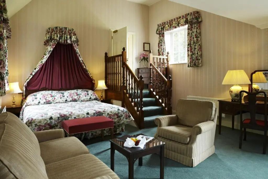 Geräumiges Hotelzimmer mit Treppe und Sitzbereich im Landhausstil.