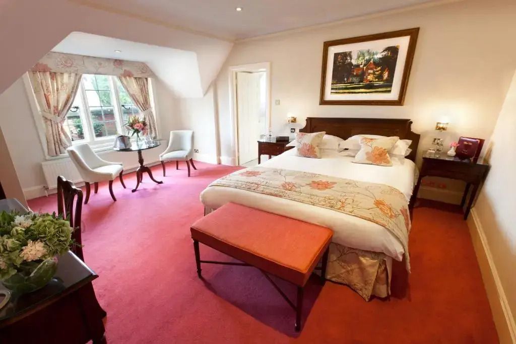 Klassisches Hotelzimmer mit Doppelbett und eleganter Einrichtung in warmen Farben