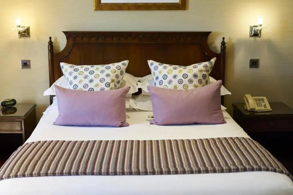 Detailansicht eines Bettes mit dekorativen Kissen in einem klassischen Hotelzimmer