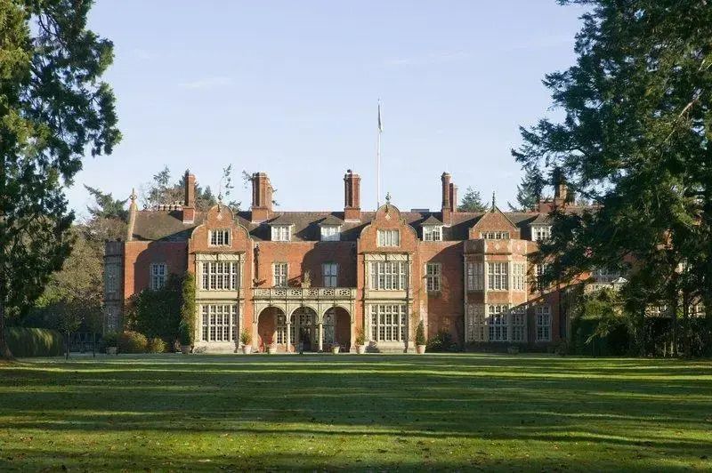 Historische Backsteinfassade von Tylney Hall umgeben von grüner Landschaft