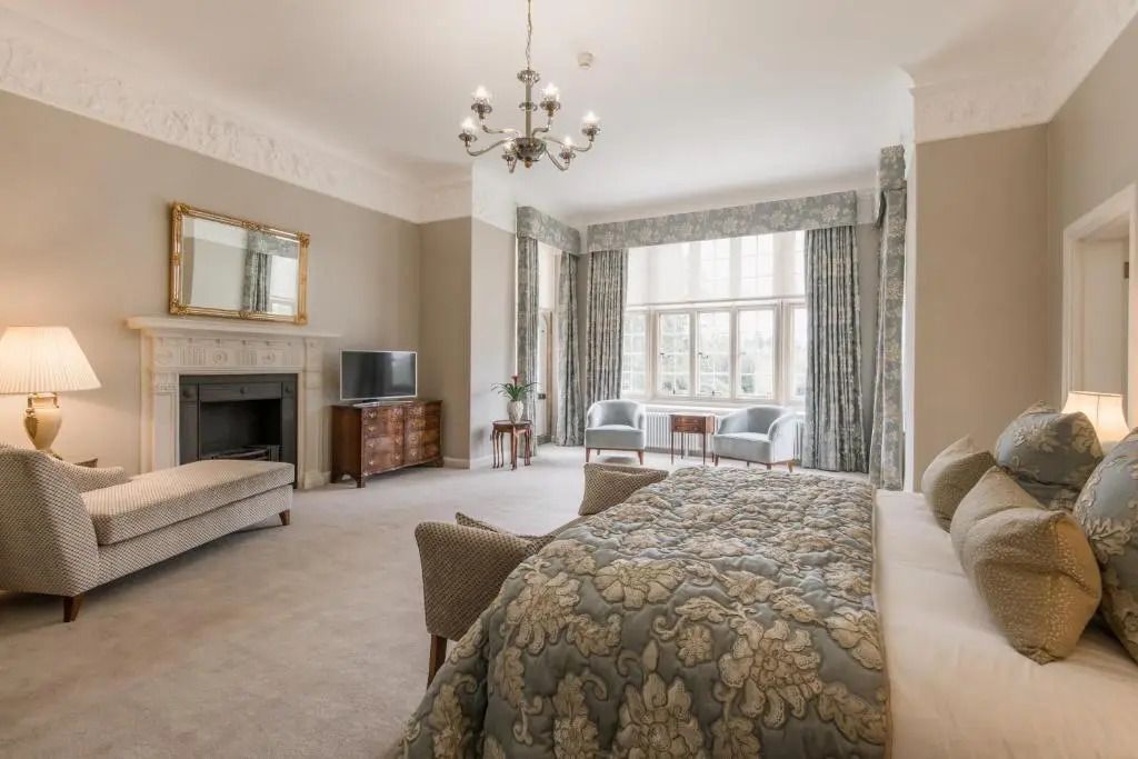 Geräumige Suite mit Kamin und stilvoller Einrichtung im Tylney Hall Hotel.