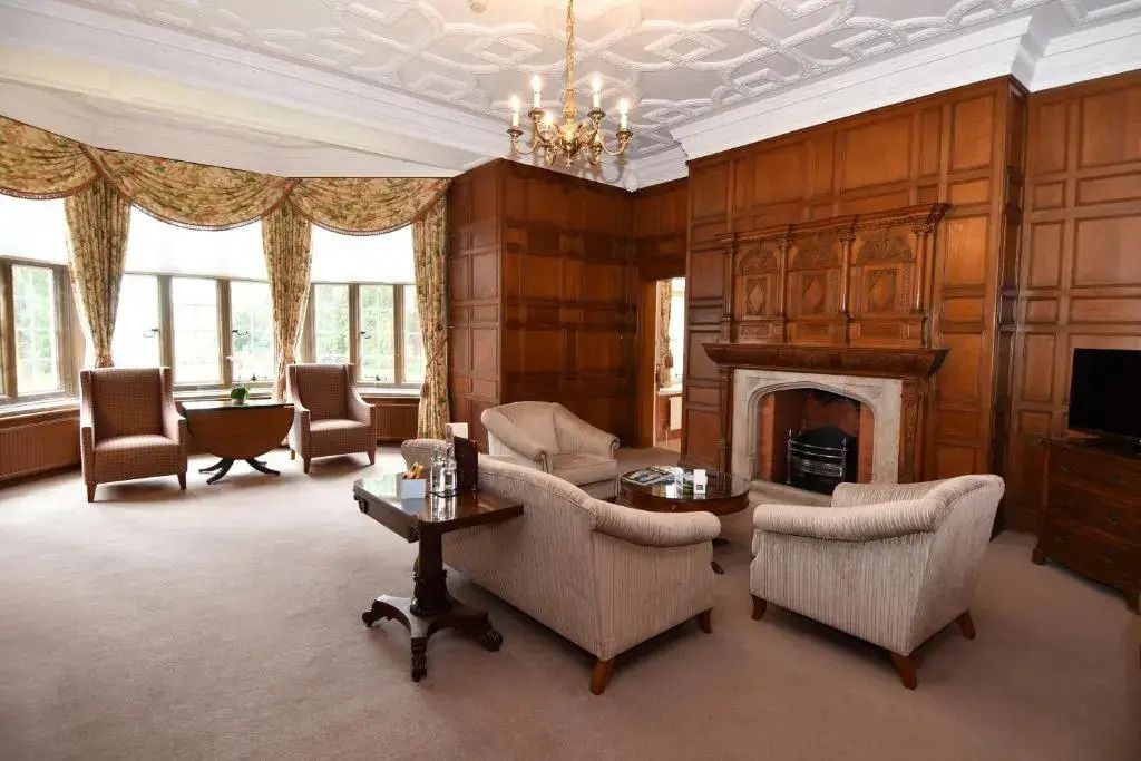 Komfortables Wohnzimmer in der Suite des Tylney Hall Hotels mit Holzverkleidung.