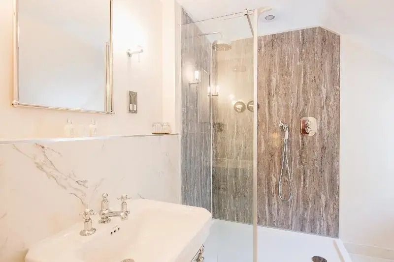 Elegantes Badezimmer der Superior Suite mit Dusche und Marmordetails