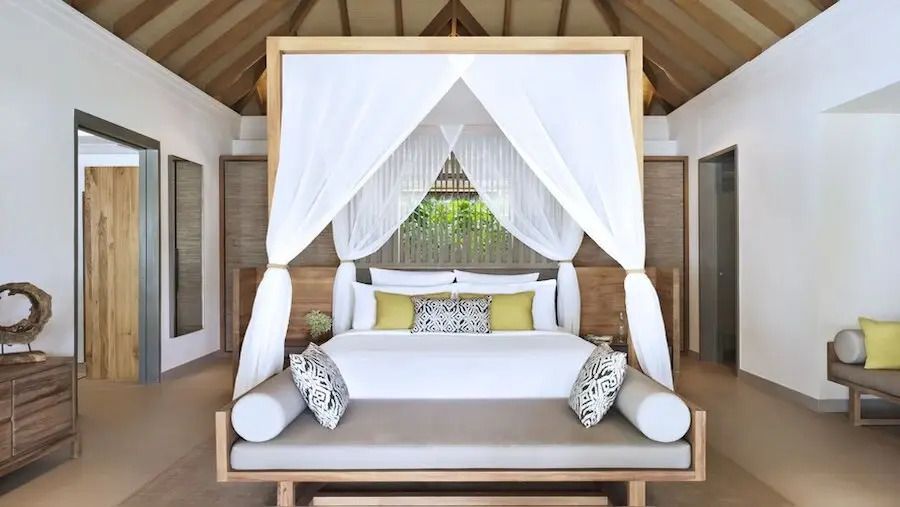 Elegantes Schlafzimmer mit Himmelbett und geschmackvollen Kissen