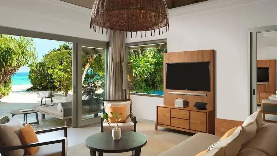 Wohnbereich mit stilvoller Rattanleuchte und Blick ins Grüne im Vakkaru Maldives.