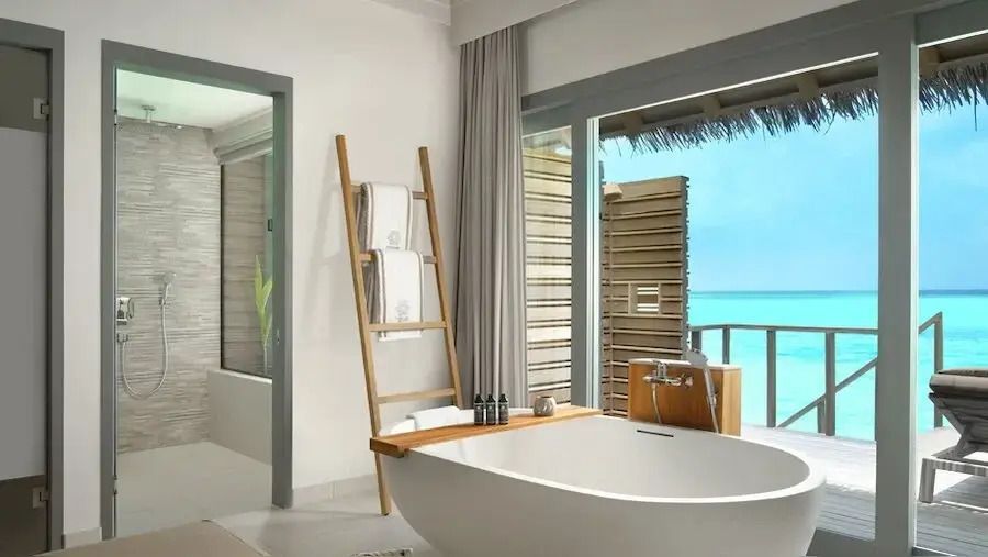 Modernes Badezimmer mit Badewanne und Aussicht auf das türkisblaue Meer