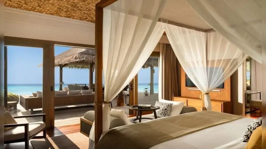 Schlafbereich mit Himmelbett in Suite mit Meerblick und Terrasse