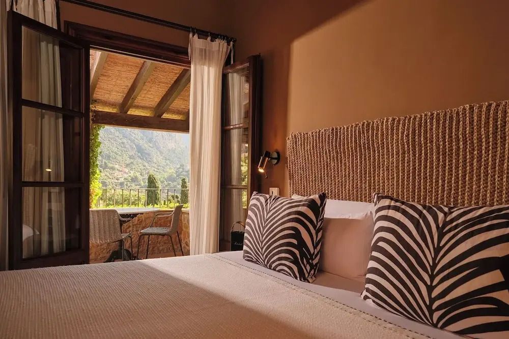 Deluxe Zimmer mit offenem Zugang zur Terrasse und Blick ins Grüne.