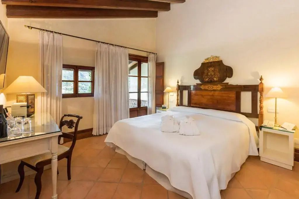 Helles Superior Doppelzimmer mit Holzbalken und klassischem Doppelbett.