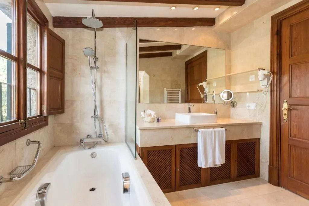 Elegantes Badezimmer mit Badewanne und großer Spiegelwand im Hotel Valldemossa