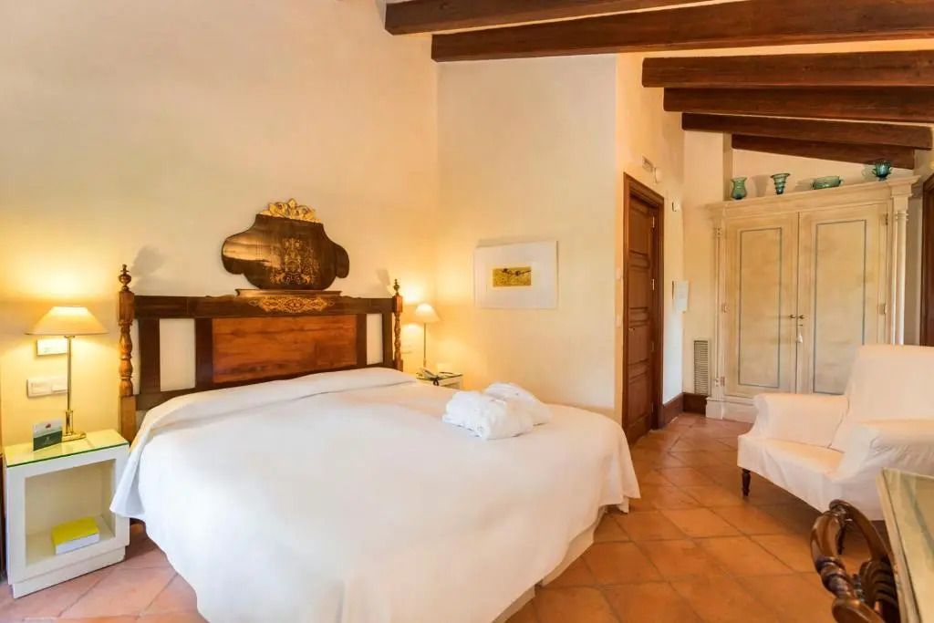 Helles Superior Doppelzimmer mit Balkon und rustikalem Holzbett im Hotel Valldemossa